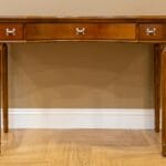 Drewniana konsola z trzema szufladami i srebrnymi uchwytami