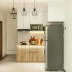 Mała minimalistyczna kuchnia z drewnianymi szafkami i nowoczesnym AGD