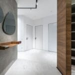 Przedpokój z dużą szafą wnękową, lustrami i drewnianą półką