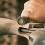 Stolarz obrabia drewniany mebel szlifierką w warsztacie