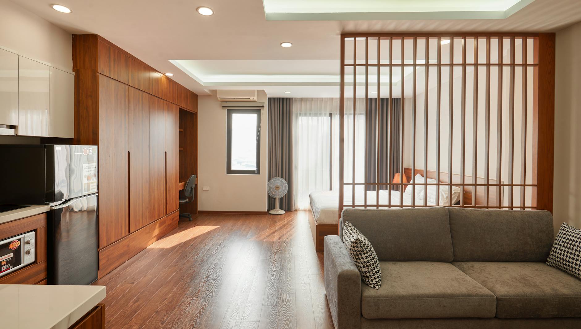 Minimalistyczny salon z łóżkiem i sofą w jednym jasnym pokoju