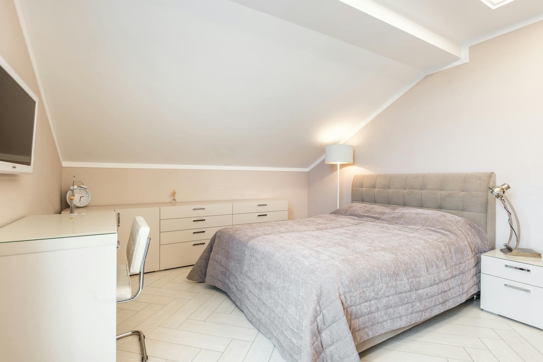 Nowoczesna sypialnia z łóżkiem, białą komodą i biurkiem pod telewizorem