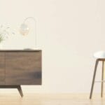 Nowoczesny salon z drewnianą komodą, krzesłem, lampą i rośliną