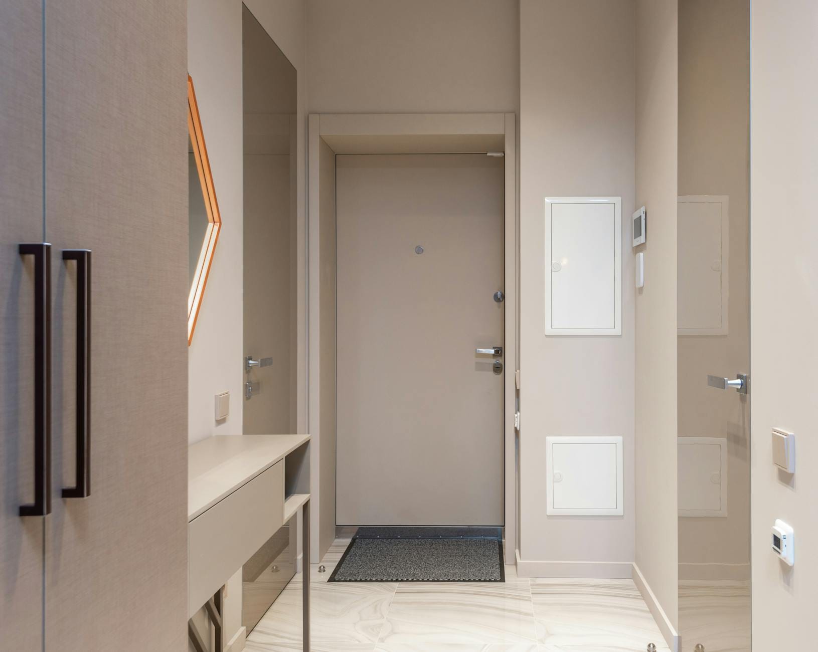 Wąski beżowy przedpokój z nowoczesnymi meblami na wymiar i dekoracjami geometric