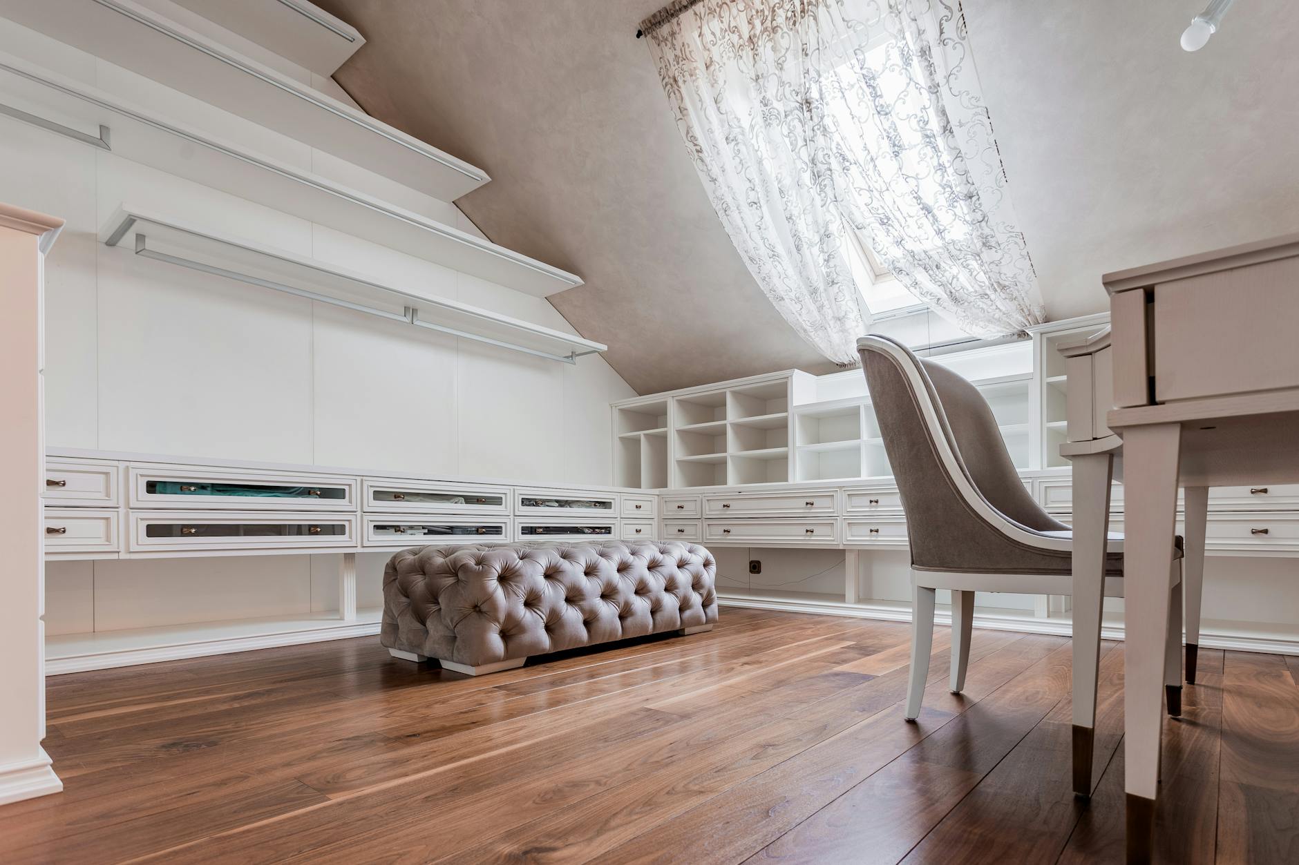 Nowoczesne studio na poddaszu z biurkiem i zabudową pod skosami