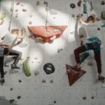 Dwójka młodych wspinaczy na ściance boulderowej w hali