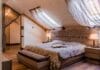 Elegancka sypialnia z luksusową pościelą, drewnem i zasłonami